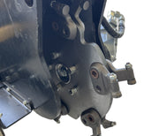 Close-up of the Paddock Swinging Stump Grinder Attachment for STRKL1200, featuring bolts, levers, and hydraulic hoses. This industrial-grade Paddock tool stands out against a white background.