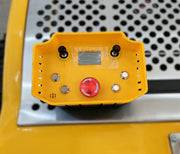The Paddock Remote Controlled Mower 7.5HP - 530mm features a yellow industrial control panel with a large red emergency stop, display screen, four metal buttons, two black switches, and ventilation holes on a perforated metal surface.