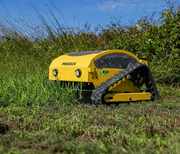 A yellow Paddock Remote Controlled Mower 7.5HP - 530mm with a track drive and 4-stroke petrol engine cuts tall grass in an outdoor field under a blue sky.