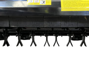 Close-up of the Paddock Walk Behind Flail Mower 12HP - 900mm shows its black metal blades beneath, arranged in a row above concrete. Yellow warning labels mark this Paddock mower, built for efficient vegetation control.