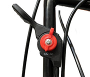 A close-up of the black and red ON/OFF switch on a Paddock Walk Behind Flail Mower 12HP - 900mm, with cables attached to the black metal frame and a person in shorts blurred in the background.