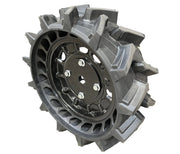 A rugged black wheel with deep, angular treads and a solid central hub with multiple lug nut holes, designed for the Paddock Walk Behind Flail Mower 12HP - 900mm, ideal for vegetation control. Brand: Paddock. Shown on a white background.
