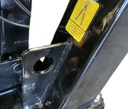 Close-up of a black metal structure on the Paddock Walk Behind Trencher with Guide Wheel by Paddock, featuring a large hole and a yellow warning label with chain and safety instructions; background is mostly white.