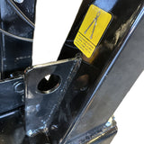 Close-up of a black metal structure on the Paddock Walk Behind Trencher with Guide Wheel by Paddock, featuring a large hole and a yellow warning label with chain and safety instructions; background is mostly white.