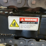 WARNING KEEP CLEAR. Foot Crush Zone on Paddock Walk Behind Trencher with Guide Wheel may pinch your foot, causing serious injury. Keep Back! Yellow symbol shows a foot being pinched. For use with Paddock portable trencher models.
