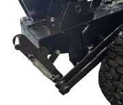 Close-up of a black metal mechanism from the Paddock Walk Behind Trencher with Guide Wheel by Paddock, showing bolts, springs, pins, and rugged tire details. The white background emphasizes the trencher's components and sturdy structure.