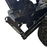 Close-up of a black metal mechanism from the Paddock Walk Behind Trencher with Guide Wheel by Paddock, showing bolts, springs, pins, and rugged tire details. The white background emphasizes the trencher's components and sturdy structure.