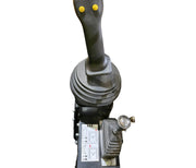 A close-up of the Paddock Tracked Cabin Loader Pro joystick showing two yellow buttons, a smaller lever, and an instruction panel with diagrams—features from this 40hp Perkins Turbo Diesel ex-demo model—isolated on a white background.
