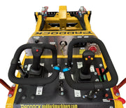Close-up of the Paddock Tracked Mini Loader Pro by Scintex featuring dual steering handles, levers, buttons, and labels. This diesel engine loader boasts a yellow and black design with brand markings, perfect for construction companies needing efficiency and power.