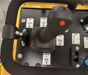 Close-up of the control panel on the Paddock Tracked Mini Loader Pro (40hp Perkins Turbo Diesel), featuring a joystick with left, right, forward, and backward labels, a red button on top, and multiple switches—typical of Paddock construction equipment.