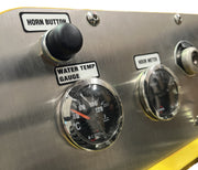 Close-up of the metal control panel on a Paddock Tracked Mini Loader Pro (40hp Perkins Turbo Diesel), featuring labeled black horn button, water temperature gauge, and hour meter—standard in Paddock machinery.