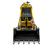 Front view of a yellow and black Scintex Paddock Tracked Mini Loader with diesel engine and bucket attachment, highlighting attachment compatibility. Hydraulic hoses and branding are visible. The loader is shown on a white background.